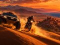 Una moto de rally y un 4x4 corren por las dunas marroquíes al atardecer, con el pueblo y el mar al fondo: el Dakar 2027 regresa a África